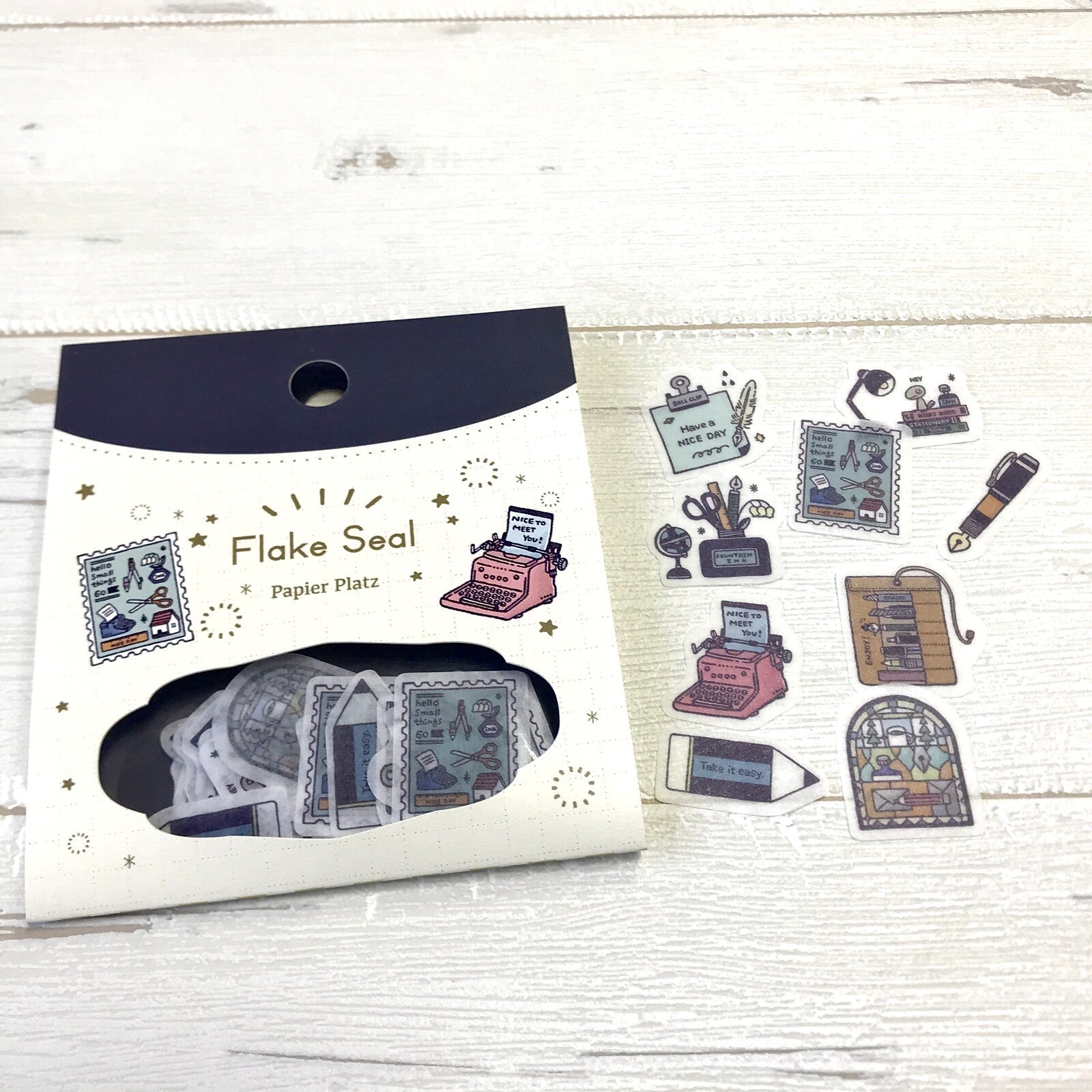 Packaging of Flake Seal stickers with typewriter design on a wooden surface, cute, japan, stickers, flake seal, eric small things, hope and letters, nz, journal, pen, pencil, 