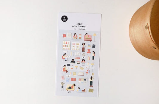 A sheet of daily desk planner stickers with cute, minimalist cartoon illustrations of people working, studying, and relaxing, displayed on a clean white surface next to a wooden bowl. korea, nz, stationery
