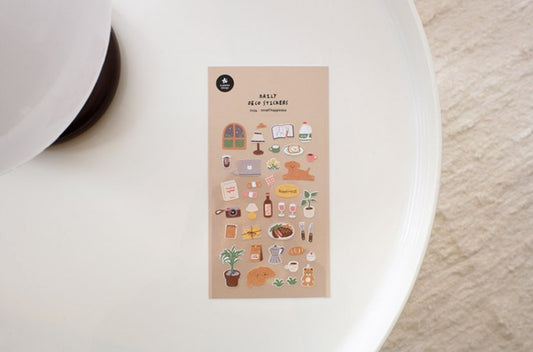 A suatelier sticker sheet with the title 'daily deco stickers' and small illustrated school-themed stickers, placed on a white plate against a light textured backgground, nz, dog, cute